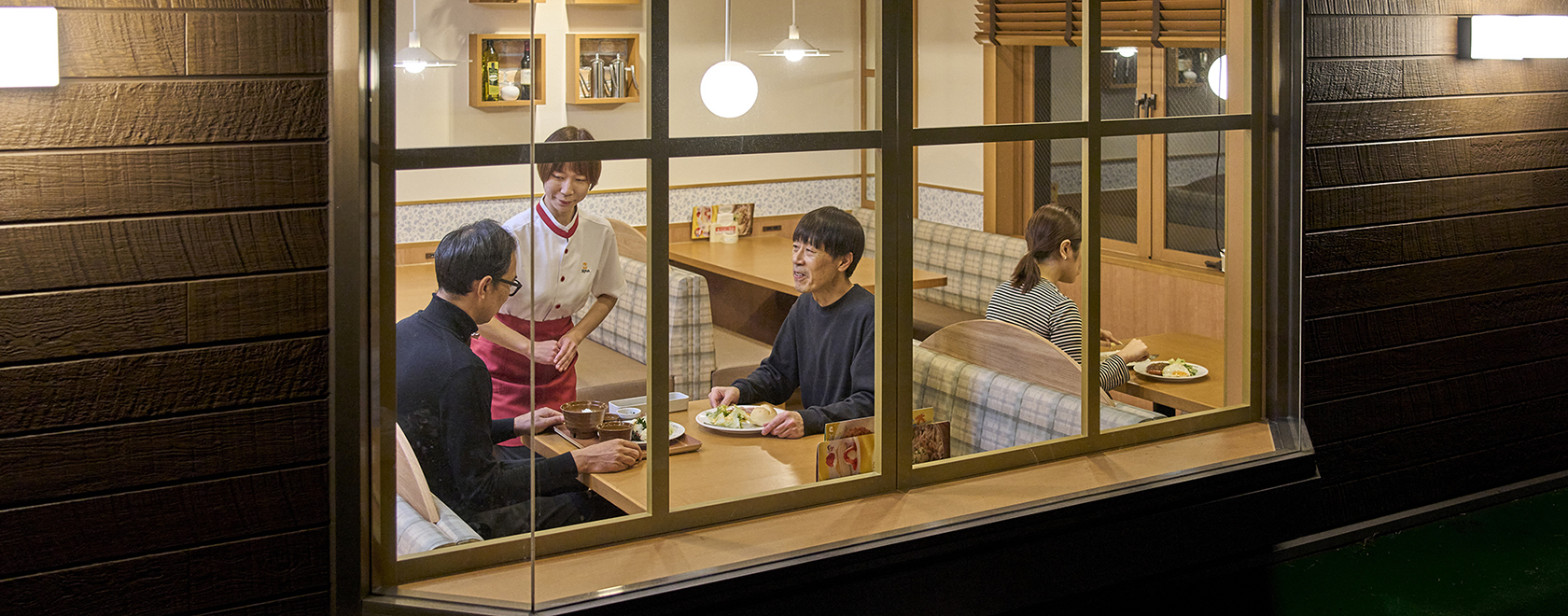 夜の店内で食事を楽しむお客様とスタッフの様子