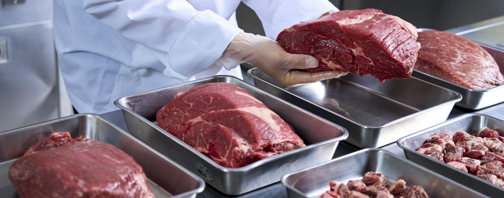 調理スタッフが大きな牛肉の塊を扱っている様子