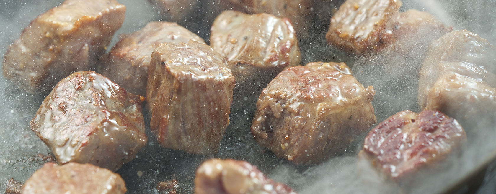 鉄板でジューシーに焼かれるカットステーキ