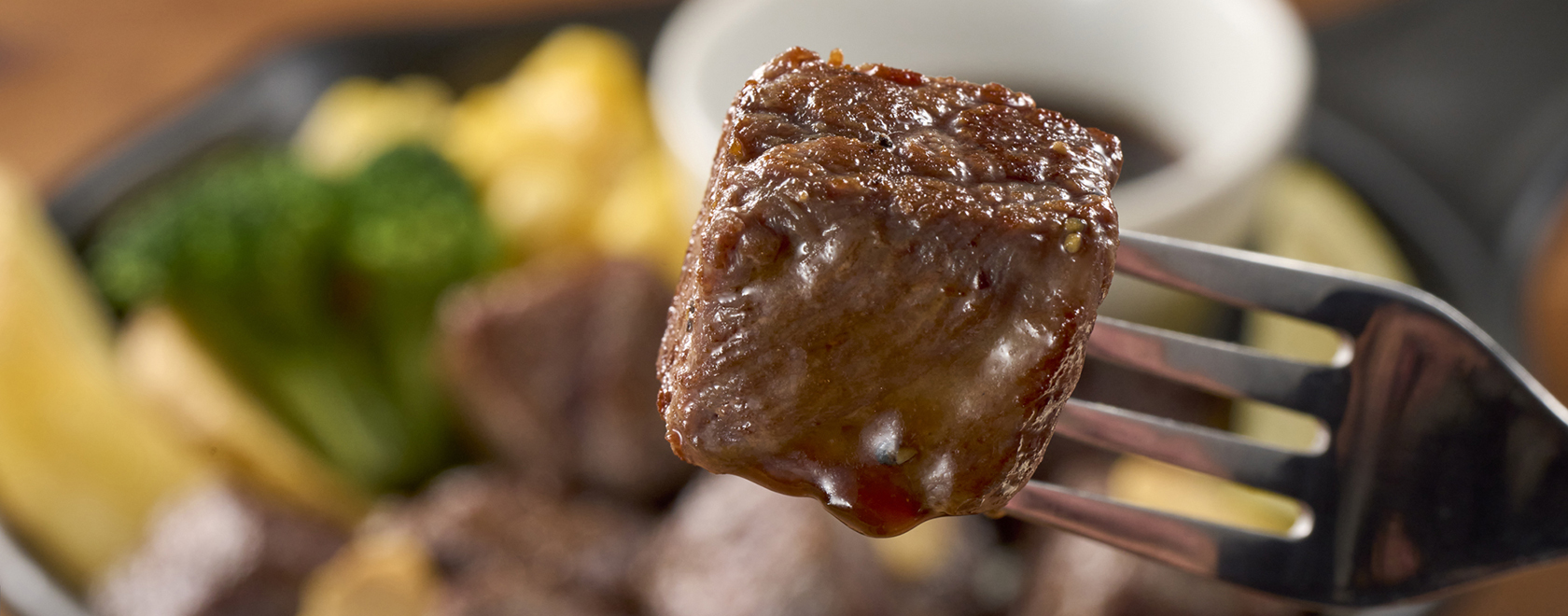 フォークに刺したジューシーなステーキ肉